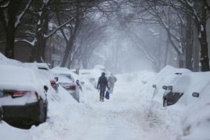 Pedestrians make their way along a snow covered street during a winter snow storm in Cambridge